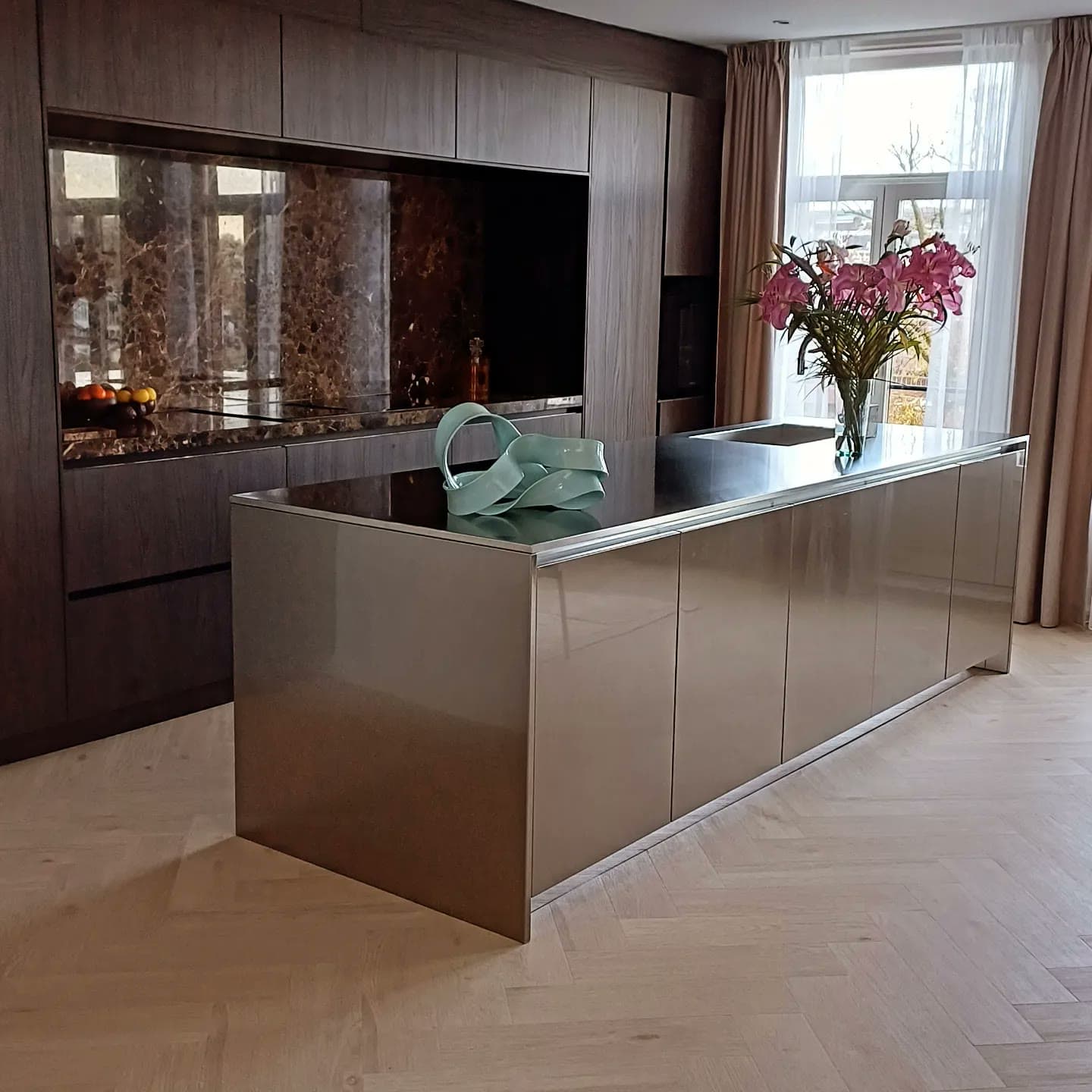 Emperador marble and champagne metal island in a finished kitchen